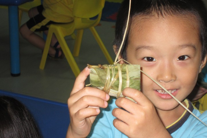 Proudly holding up his zongzi  